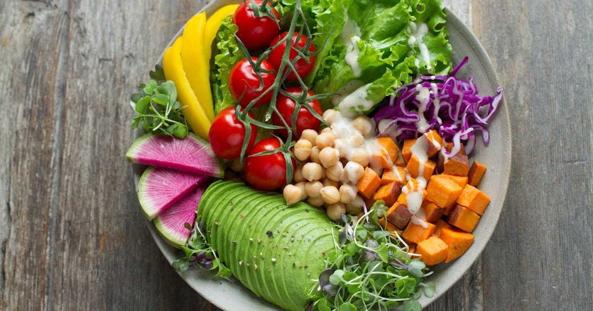 Colorful bowl of fresh vegetables including tomatoes, avocado, and chickpeas representing healthy nutrition for metabolic health
