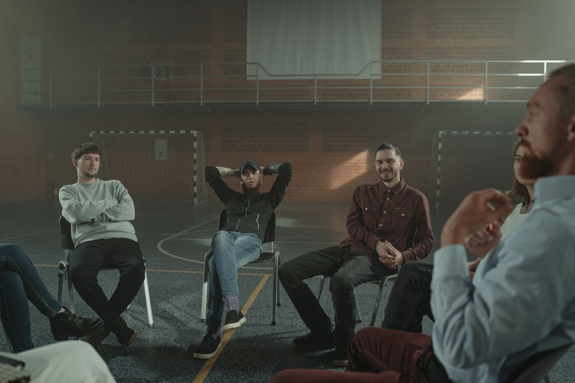 People gathered in a hall participating in a group therapy session
