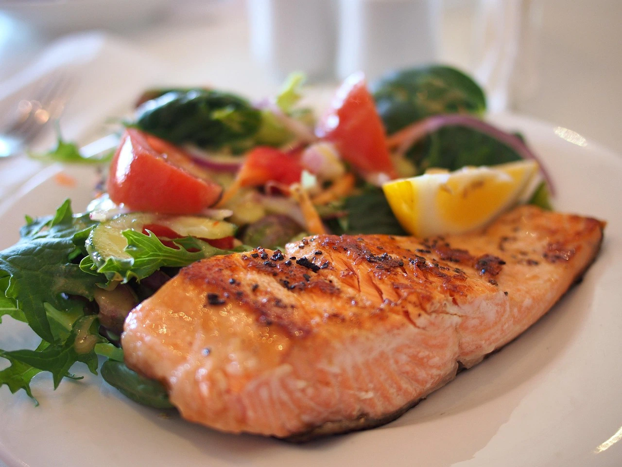 Grilled salmon fillet served with fresh vegetables and lemon